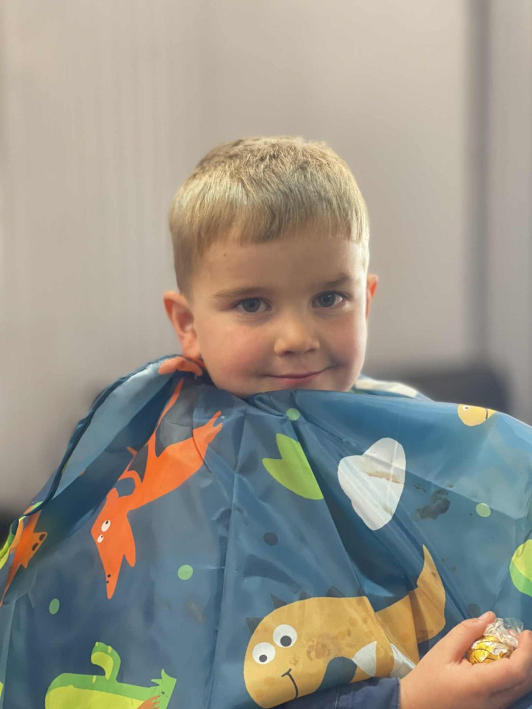 A young customer smiling after his haircut